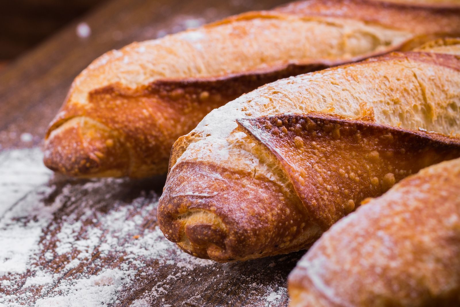 Frische französische Baguettes auf bemehltem Holz